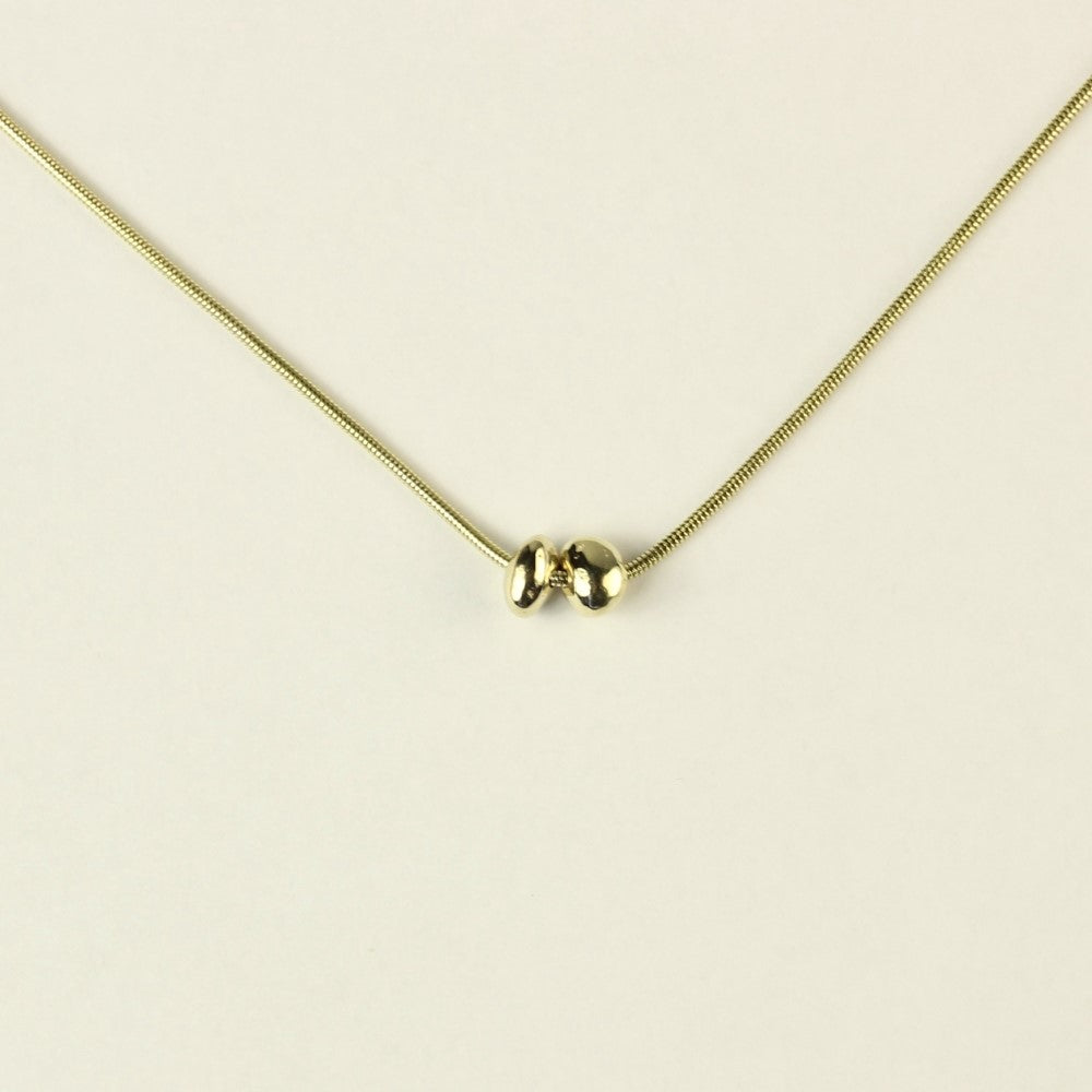 14 karaat gouden hanger Essentials: 2 minimalistische organische gouden steentjes aan een ketting. Hangend voor een witte achtergrond.