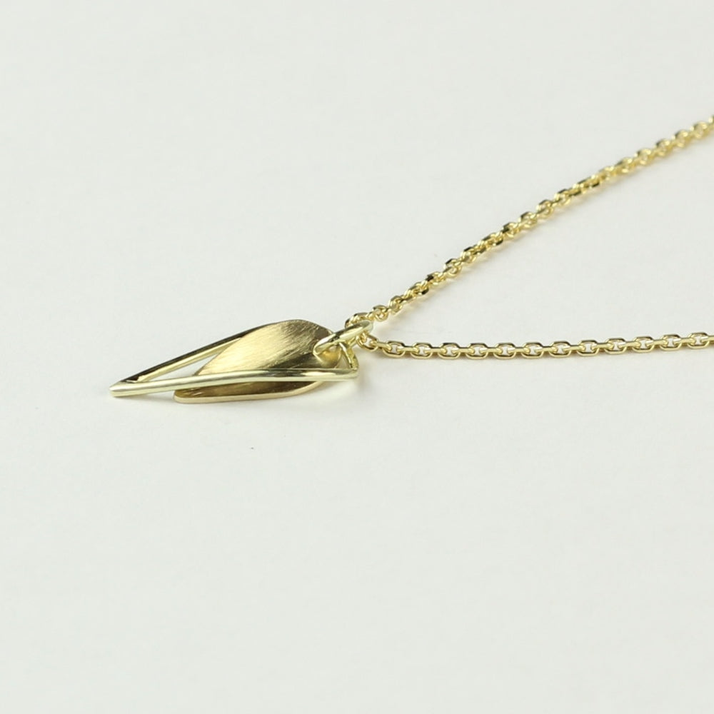 Dubbel hangertje Leaves, minimalistisch gouden blaadje met daaromheen een open blaadje gemaakt van gouddraad als omlijsting. Getoont op witte achtergrond aan een gouden ketting.