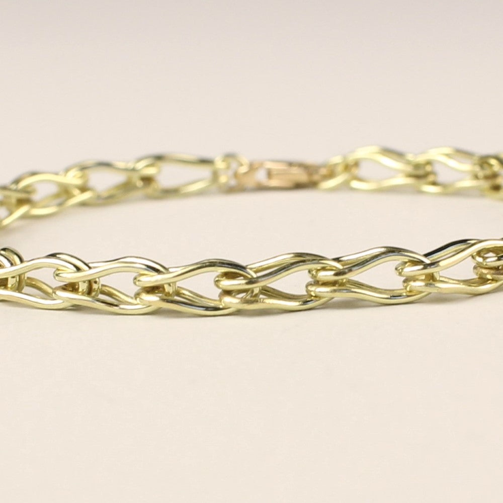 Zijaanzicht close-up van een 14 karaat gouden schakelarmband vossenstaart, handgemaakt door goudsmid / Edelsmid Monique Zonneveld. Liggend op een witte achtergrond.