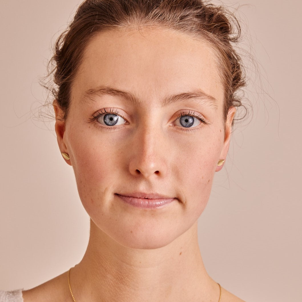 vooraanzicht gezicht van model wat oorstekers Leaves draagt. Minimalistische blaadjes van 14 k goud